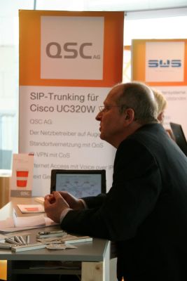 Cisco Expo 2012: QSC-Produktmanager Andreas Steinkopf am QSC-Stand im Gespräch.