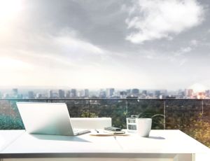 Laptop and paperwork on balcony table --- Image by © Ocean/Corbis