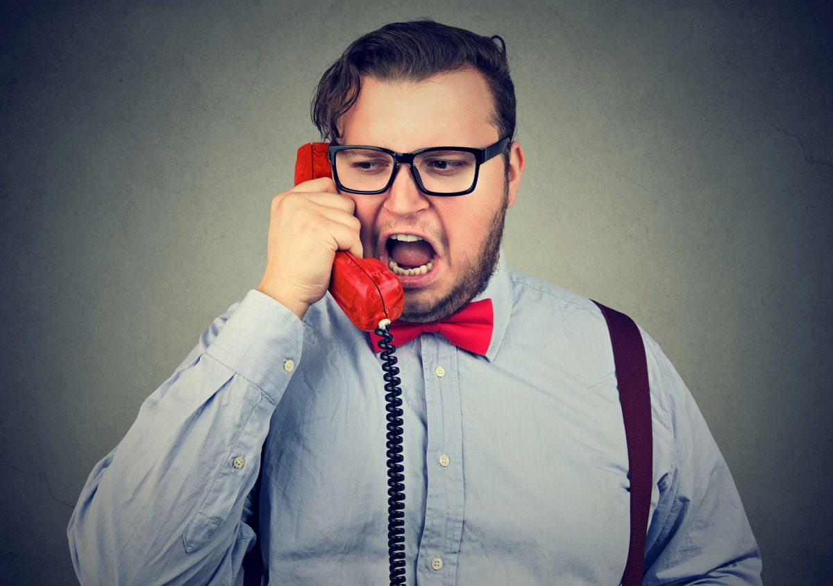 Young chubby man in formal clothing shouting in phone while having talk. Bild: © istock.com / SIphotography