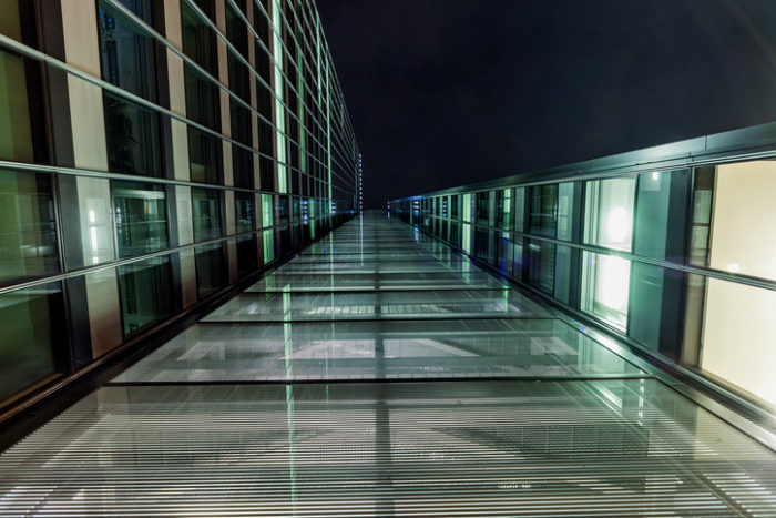 Blick auf ein Glasgebäude von unten in der Nacht